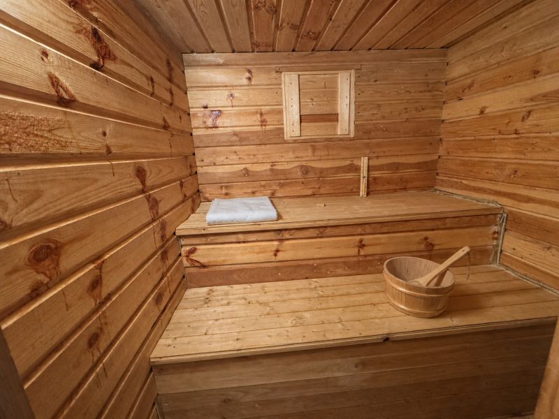 The family house includes a wooden sauna with a bucket and a towel on the bench.