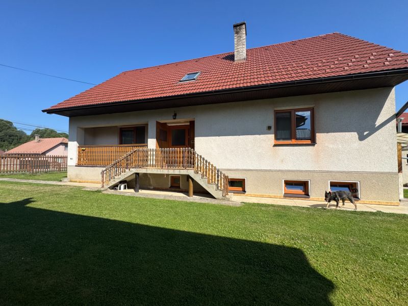 A family house in Liptovské Kľačany with a red roof and a well-maintained garden.