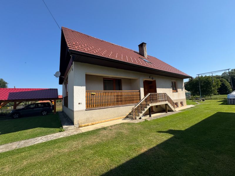 A family house in Liptovské Kľačany with a red roof and a lawn in the garden.