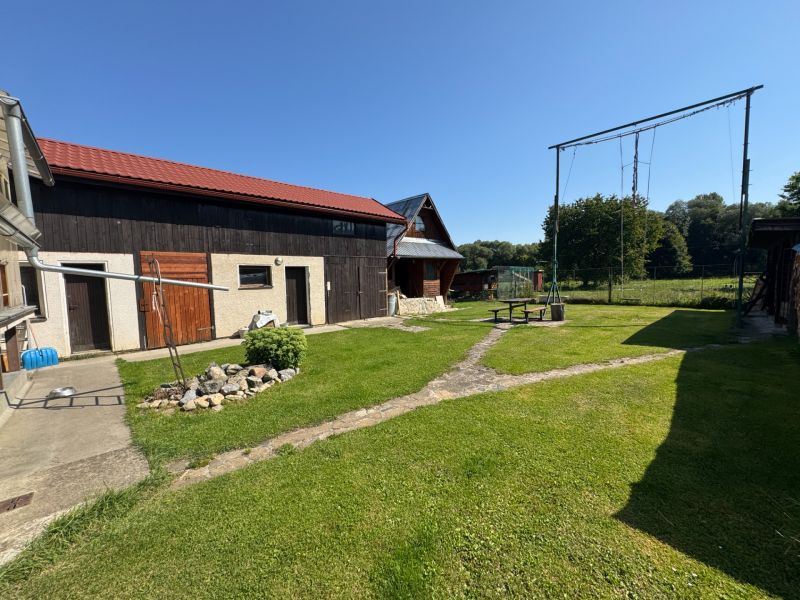 A family house in Liptovské Kľačany with a yard, swings, and a manicured lawn.