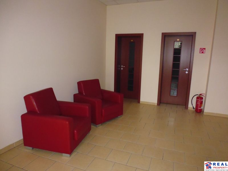 Offices: Red chairs next to two doors and a fire extinguisher on the tiles.