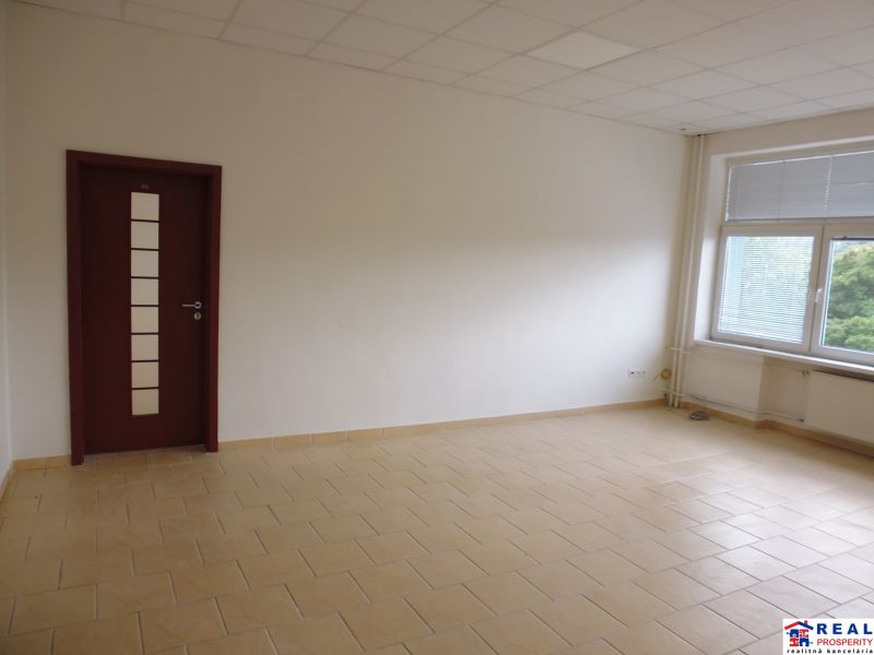Spacious offices with tiles and a window providing natural light.