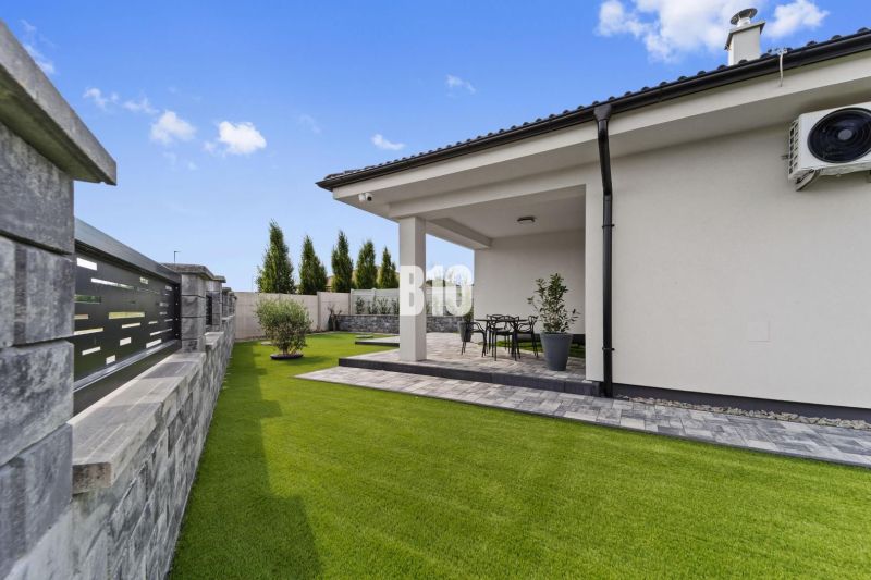 A grassy yard and terrace of a family house in Nitra with garden furniture.