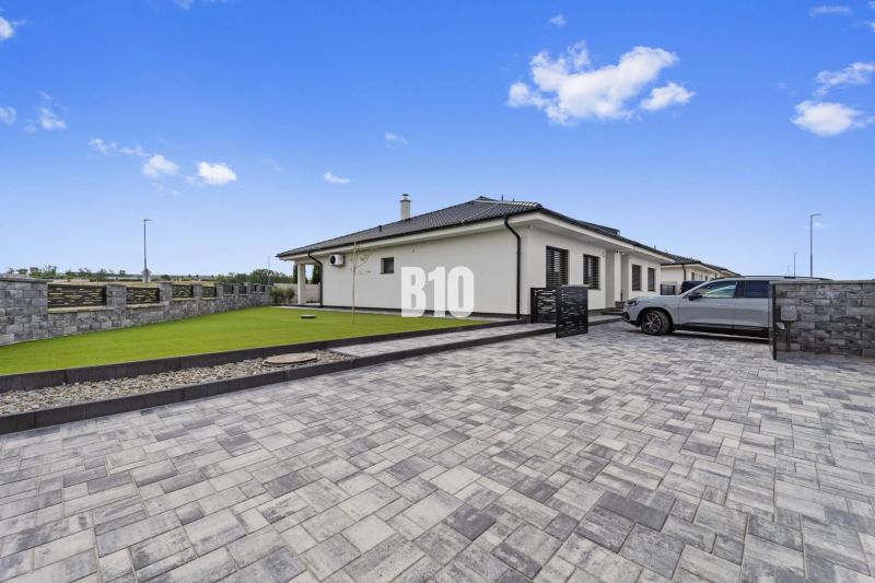 A family house in Nitra with a paved courtyard and a landscaped lawn.