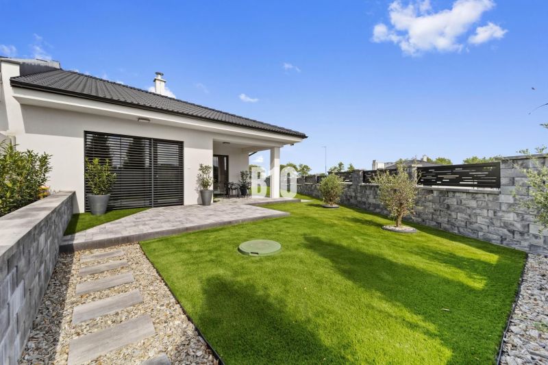 A family house in Nitra with a garden, lawn, and terrace surrounded by a wall.