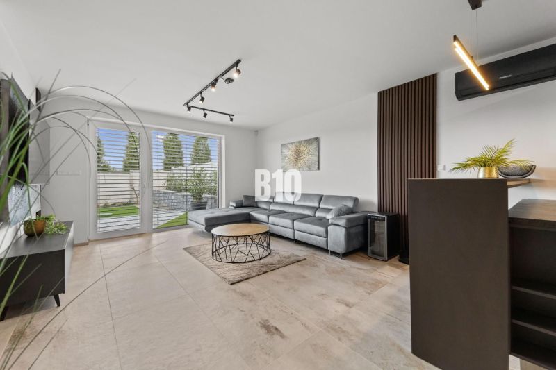 Living room with a leather sofa and windows to the terrace in a family house.