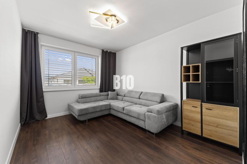 Living room with a corner sofa, wooden decor flooring, cabinet.
