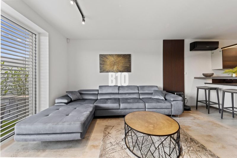 Gray sofa set, round table, and painting in the living room of a family house.