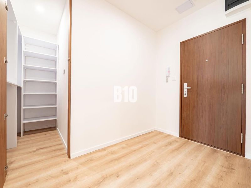 Entrance hallway of a 3-room apartment with a wood-patterned floor and a built-in wardrobe.