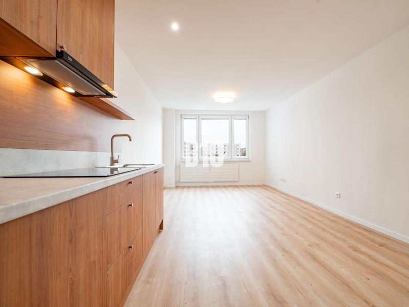 A kitchen in a 3-room apartment with a wooden decor floor, minimalist design.