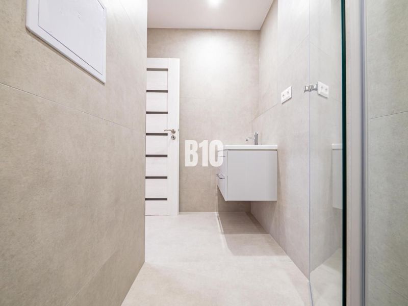 Bathroom in a 3-room apartment with a simple design and a wall-mounted sink.