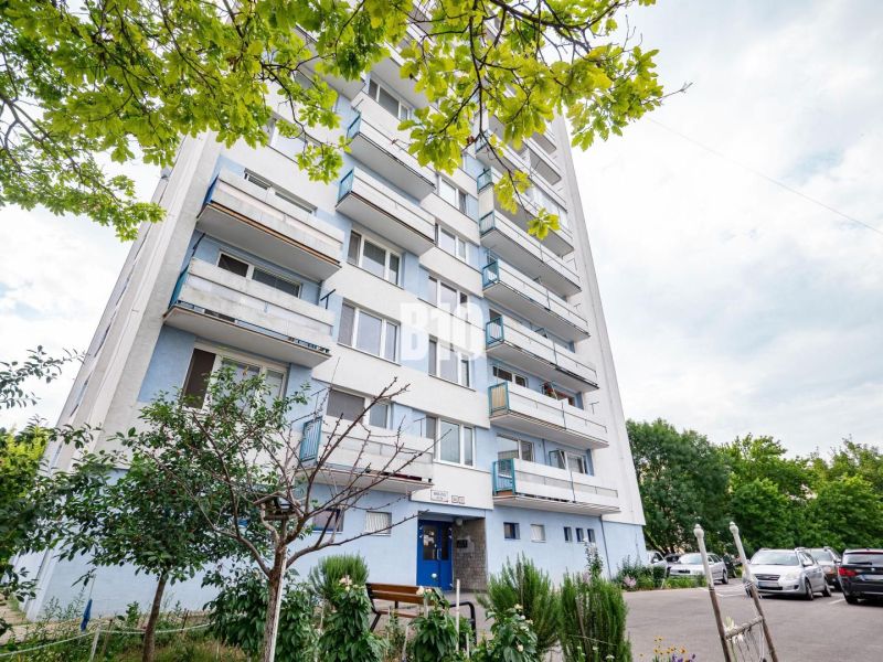 Apartment building in Nitra with trees and parking in front of a 3-room apartment.