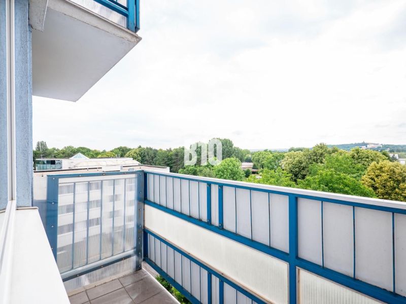 The balcony of a 3-room apartment in Nitra with a view of greenery and rooftops.