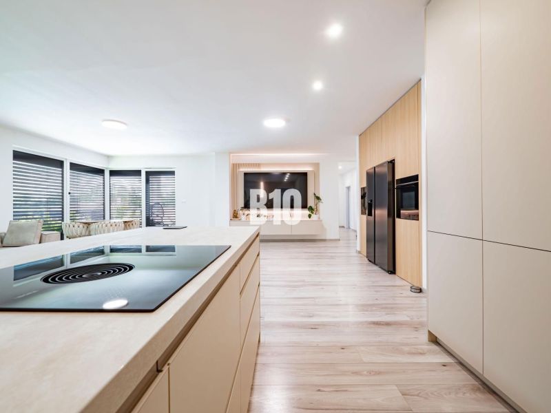A kitchen in a family house with a wooden decor floor and modern furnishings.