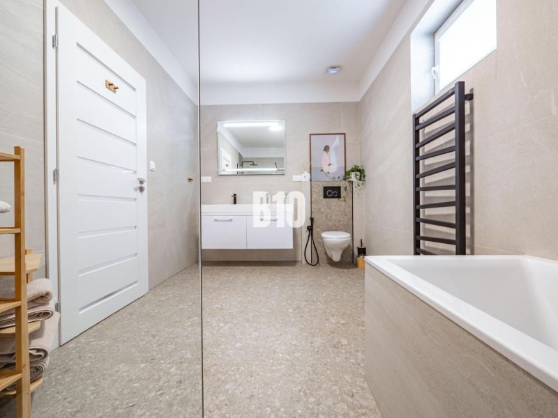 A spacious bathroom in a family house with an elegant bathtub and a modern sink.