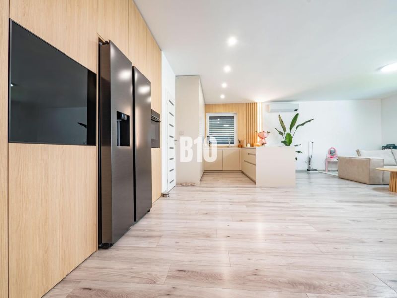 Spacious living room with wood-patterned flooring in a family house.