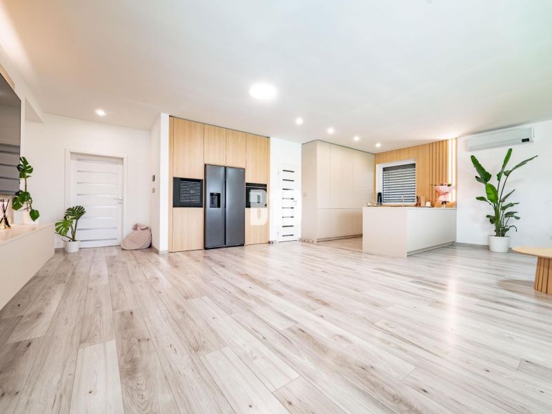 Interior of a family house with a wooden decor floor and a modern kitchen.