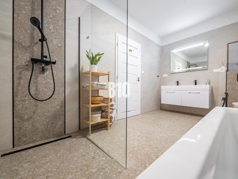 A bathroom with a modern shower and bathtub in a family house.