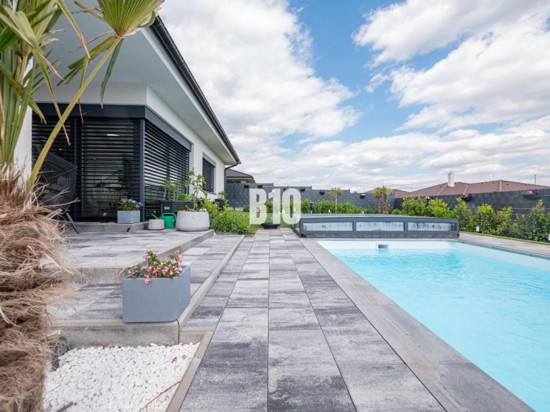 A family house in Nitra with a terrace, swimming pool, paving, and exotic plants.