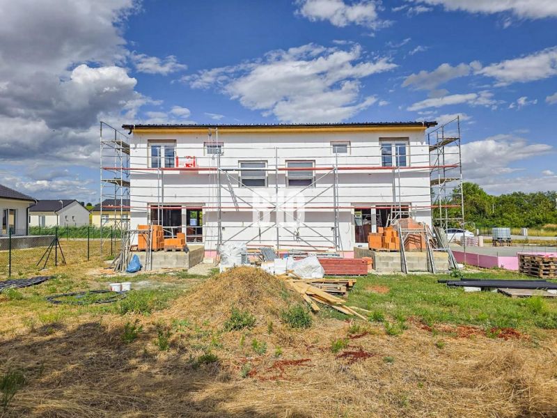 Construction of a family house in Nitra with scaffolding under construction and materials on the site.