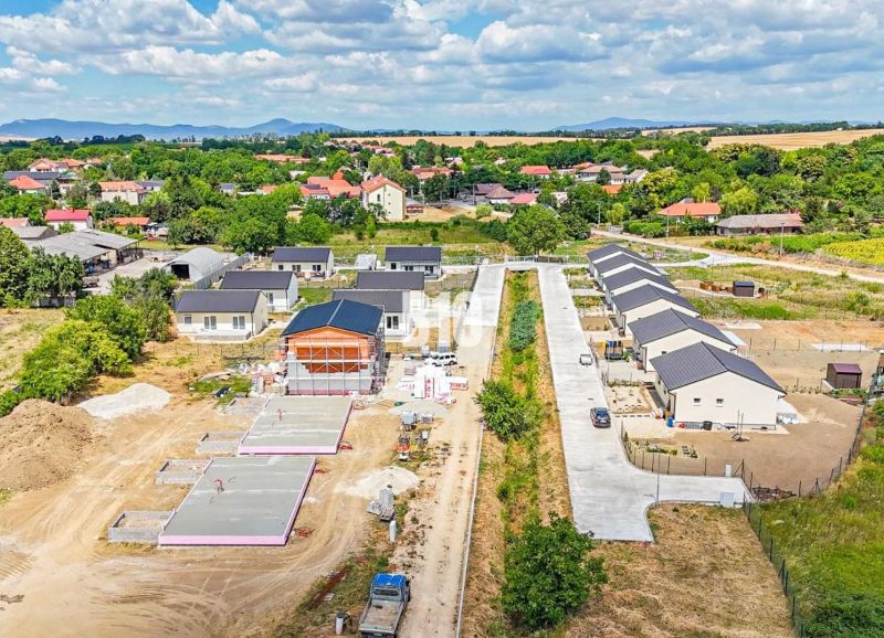 Construction of family houses in Nitra surrounded by green landscapes and other properties.