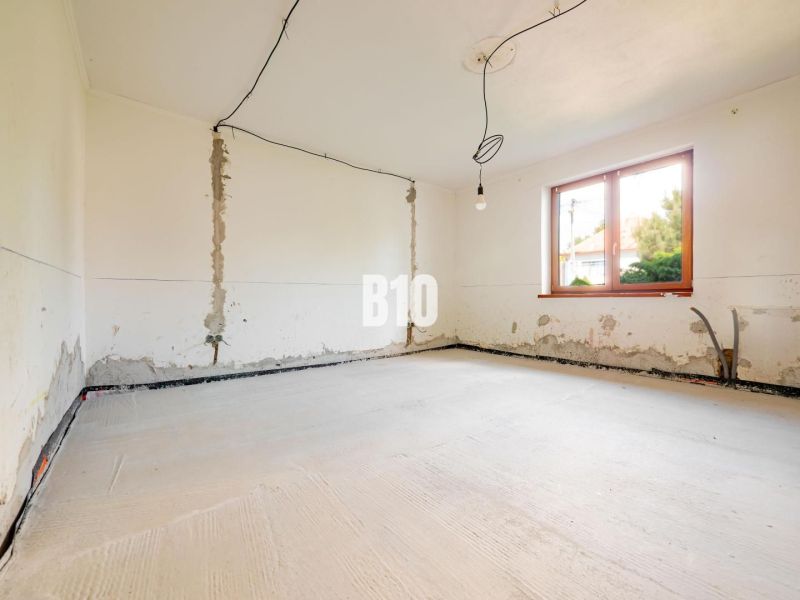Room for renovation with a window and lighting in a family house.