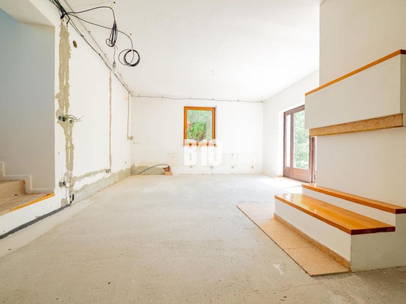 A spacious living room in a family house prepared for renovation.