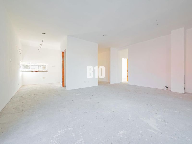 A spacious interior with white walls and a concrete floor in a family house.