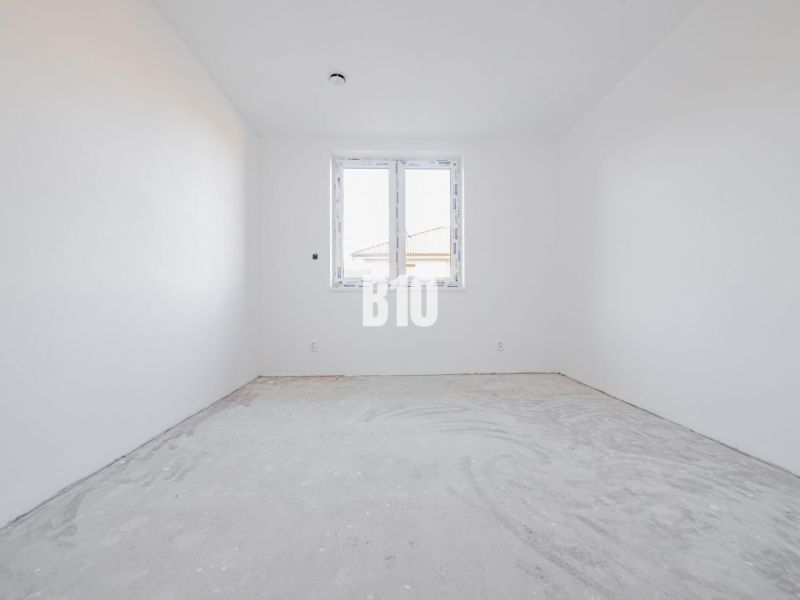 Empty room in a family house with a concrete floor and a plastic window.