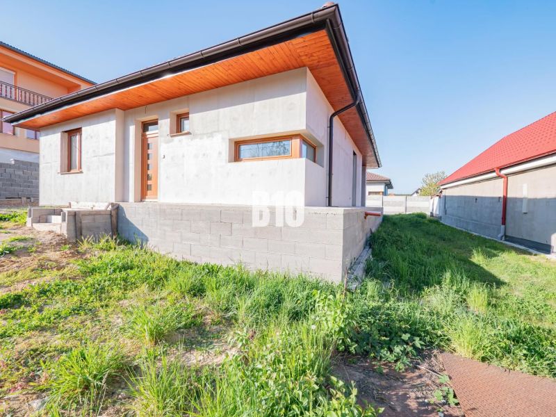 A family house in Nitra with an unpainted facade and a grassy plot.