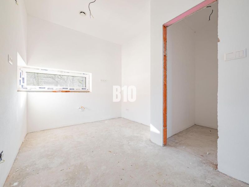Empty room with a skylight and an open passage in a family house.