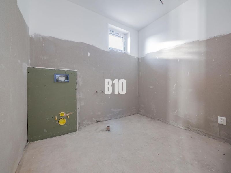 An unfinished room with a window and preparation for installation in a family house.