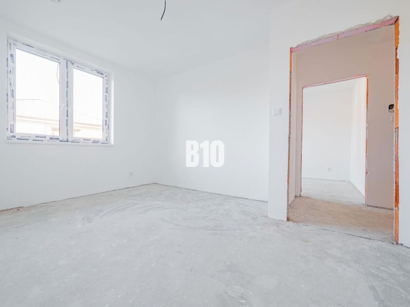 The interior of a family house with white walls and a concrete floor.