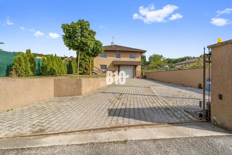 A family house in Nitra with a paved driveway and a landscaped garden.
