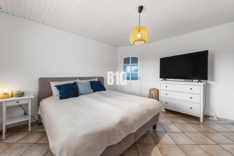 Bedroom in a family house with a bed, television, and nightstand.