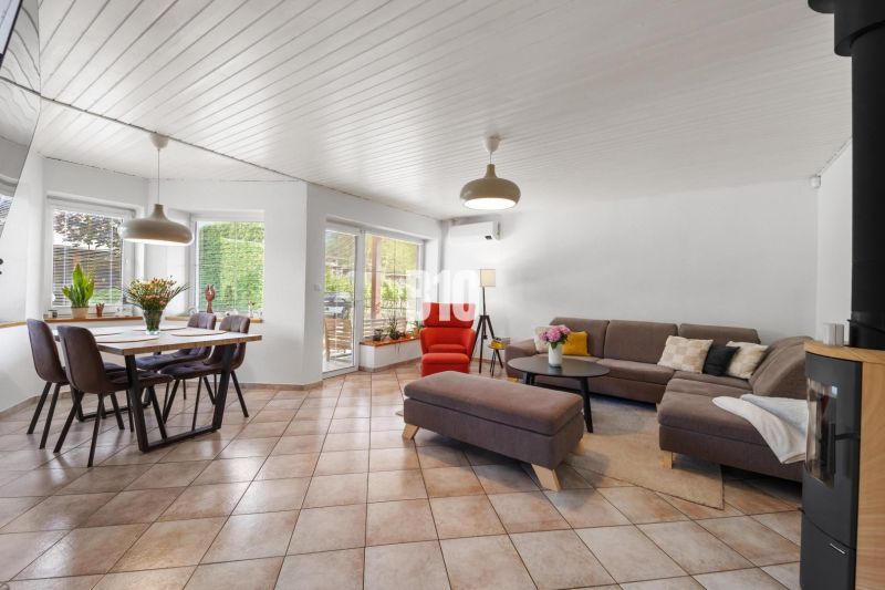 A spacious living room in a family house with a dining table and a comfortable sofa.