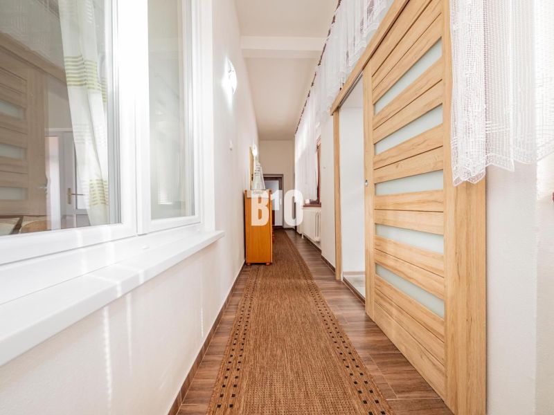 A hallway in a family house with a wooden decor floor and sliding doors.