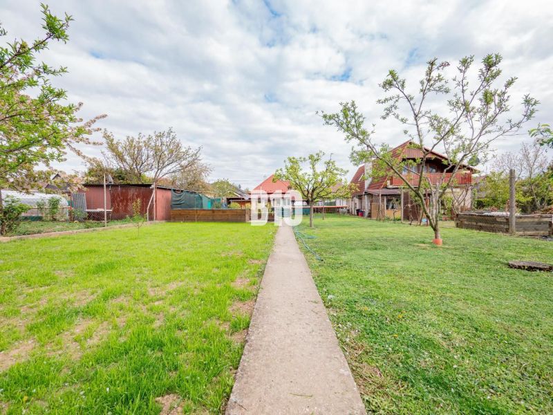 The garden of a family house in Nitra with a lawn and a walkway.