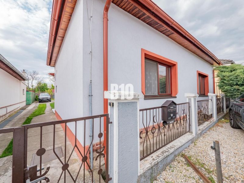 A family house in Nitra with a white facade, red trim, and a garden.