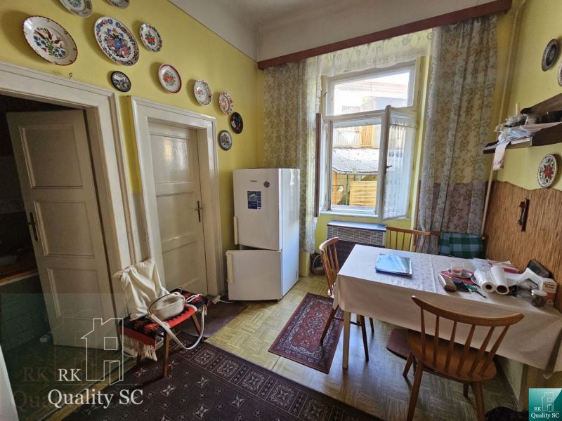 A kitchen in a 2-room apartment with wall plates and a wooden table.