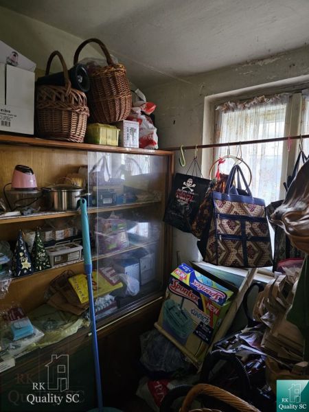 A room with storage spaces, baskets, and cleaning supplies in a 2-room apartment.