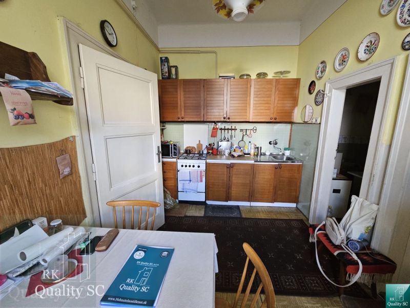 A kitchen unit with a wooden decor in a 2-room apartment with traditional decorations.