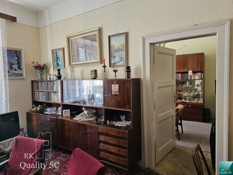 Living room in retro style in a 2-room apartment with a wooden decor floor.