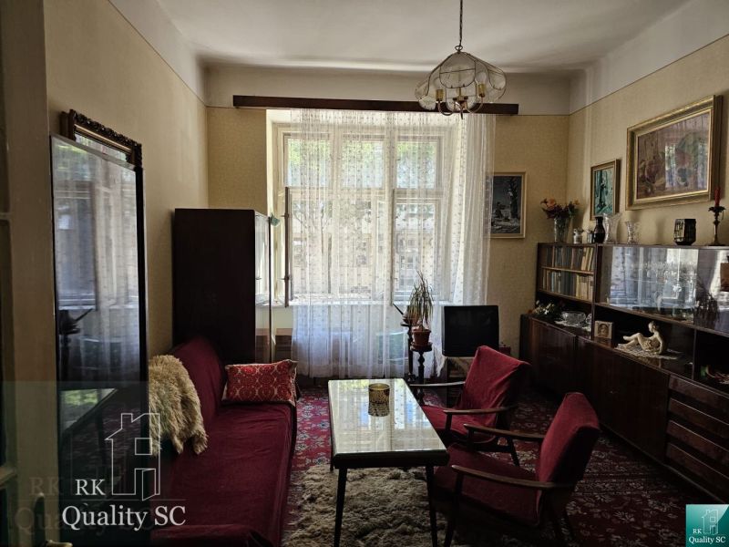 Living room in a 3-room apartment with retro-style furniture and a carpet.