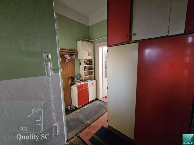 Interior of a 2-room apartment with a colorful kitchen unit and a telephone on the wall.