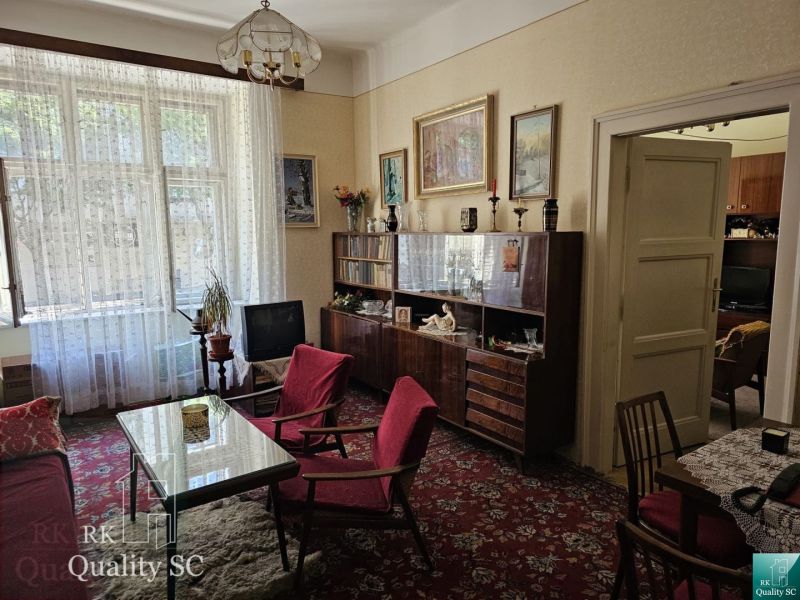 Living room in a two-room apartment with retro furniture and red armchairs.