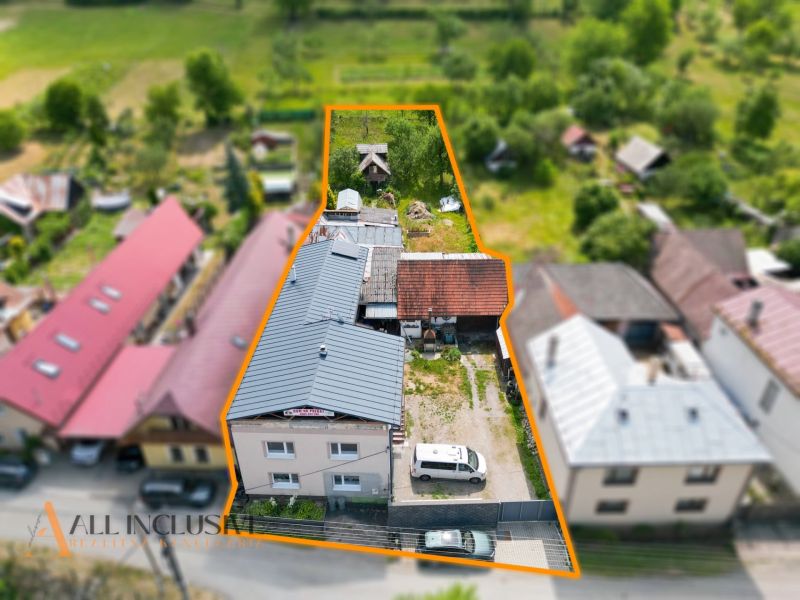 A family house in Dúbravica with a courtyard and garden, surrounded by neighboring houses.