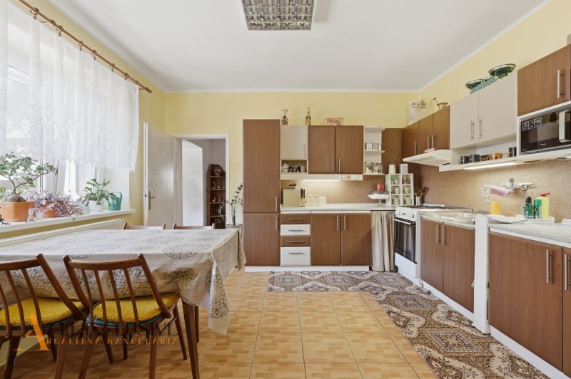 A kitchen in a family house with classic furnishings, a wooden decor floor, and a dining table.