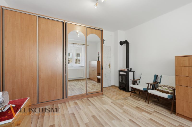 A room in a family house with a fireplace, a wardrobe, and a floor with a wooden decor.