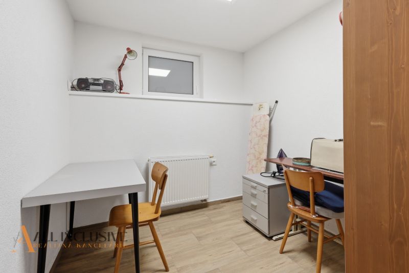 A study room in a family house with a wooden decor floor, tables, and chairs.